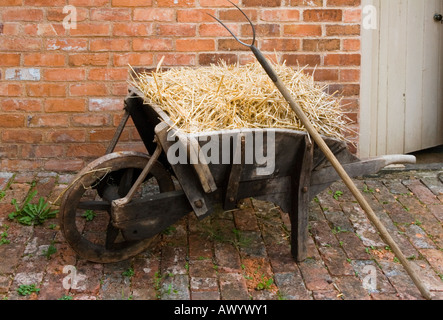 A wheelbarrow filled with straw  at Rosedene the cottage in which early Chartists lived first occupied in 1849 Worcestershire Stock Photo