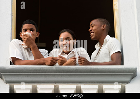 Three Cuban students smiling on the window. Stock Photo