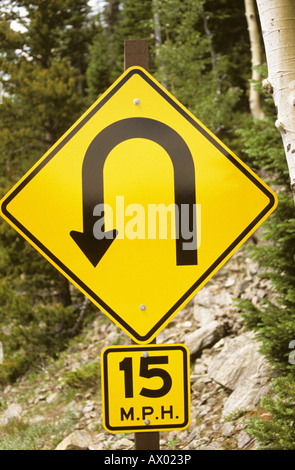 Road warning sign tells of severe curve ahead Stock Photo