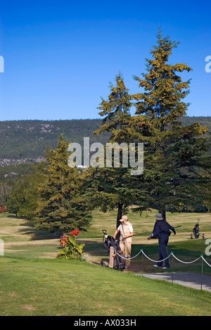 Two women stretching at 'tee off' on Tadoussac golf course on a beautiful sunny summer day Stock Photo