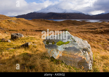 Glen Garry, looking across Loch Quoich to Gairich, lichen-covered rock boulder Stock Photo