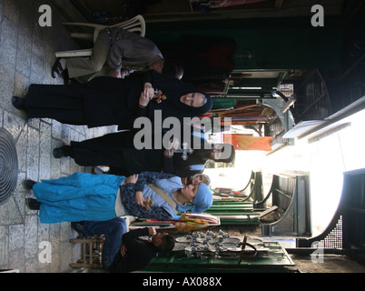 A group holding crosses walks through a market in the old city section of Jerusalem Stock Photo