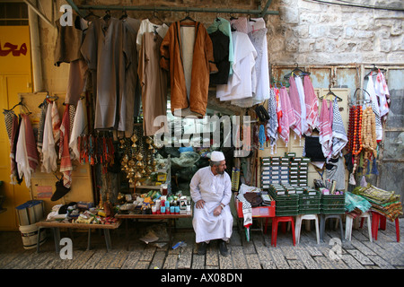 A vendors sits outside his stand at a market in the old city section of Jerusalem Stock Photo