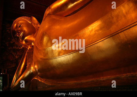 The golden Reclining Buddha statue in the holy temple Wat Pho near Bangkok Stock Photo