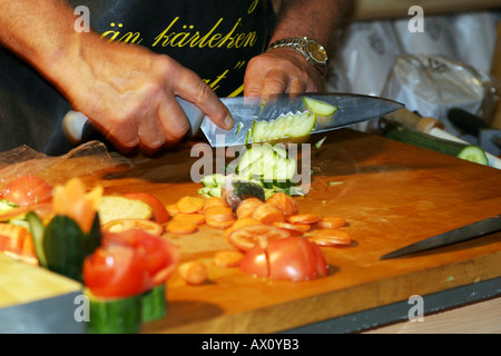 Salesman showing how to use his sharp knives at a fair Stock Photo