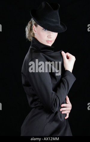 Young woman dressed in long jacket and hat Stock Photo