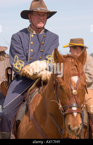 An American Civil War reenactor, representing the Confederate Army, sits astride his horse waiting for a mock battle to begin. Stock Photo