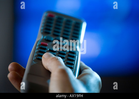 Close up of hand holding remote control Stock Photo