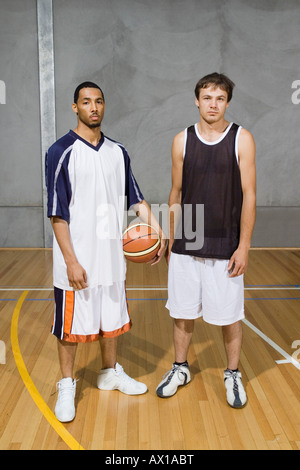 Two Young Men standing on a basketball court Stock Photo