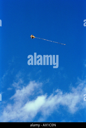 A kite flying in a cloudy, blue sky Stock Photo