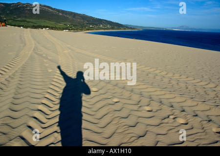 Tarifa the paloma sand dunes tires tracks and photographer shadow Stock Photo