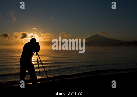 Photographer takes pictures from Vulcano Villarrica at sunrise, lake Lago Villarrica, Chile, South America Stock Photo