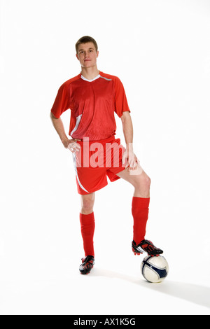 Studio portrait of soccer player with his foot on a soccer ball Stock Photo