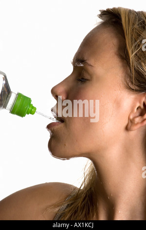 A sweating woman drinking from a water bottle Stock Photo