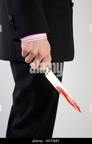A businessman holding knife with blood on it Stock Photo