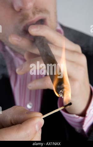 A businessman lighting a cigar Stock Photo