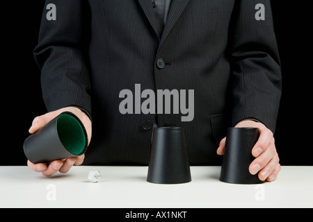 A businessman playing the shell game Stock Photo
