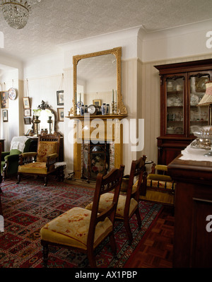 Gilt mirror above Edwardian fireplace in traditional green dining room ...