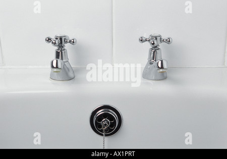 Traditional chrome taps on white acrylic bath Stock Photo