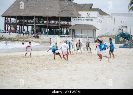 Group of Mexican men playing soccer on the beach, Playa del Carmen, Mexico Stock Photo