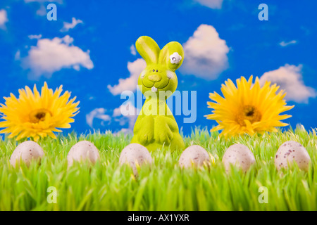 Easter bunny on meadow with Easter eggs and flowers in the background Stock Photo