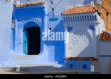 Luminous blue gate near fountain medina Chefchaouen Morocco Stock Photo