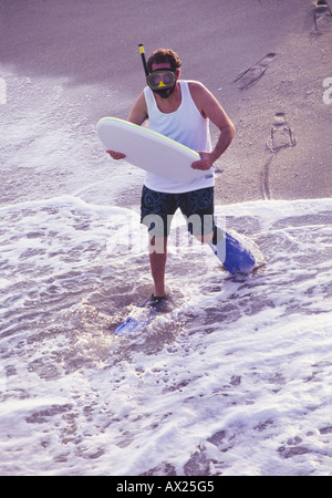 oddball man with boogie board at beach Stock Photo
