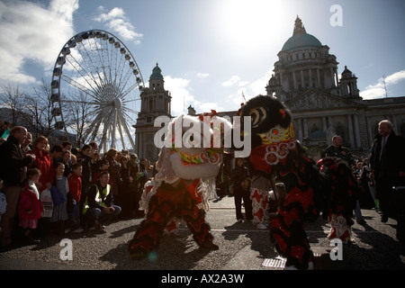 chinese dragons in the parade and carnival in front of belfast city hall and big wheel on st patricks day belfast Stock Photo