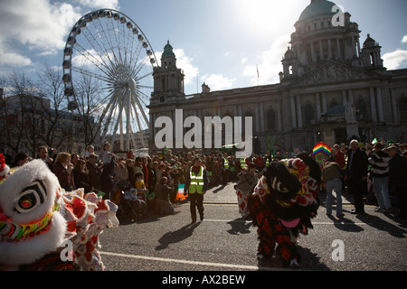 chinese dragons in the parade and carnival in front of belfast city hall and big wheel on st patricks day belfast northern irela Stock Photo