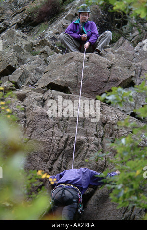 Rock Climbers, rock climbing in tandam connected by safety rope Stock Photo