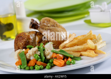 Mixed main course with half roast chicken French fries and vegetables Stock Photo