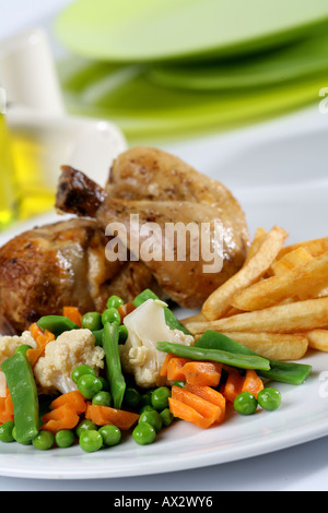 Mixed main course with half roast chicken French fries and vegetables Stock Photo