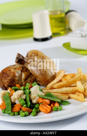 Mixed main course with half roast chicken French fries and vegetables Stock Photo