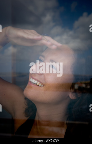 young woman looking out of window in the morning Stock Photo
