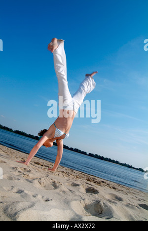 Young woman in motion at the beach, Hamburg, Germany Stock Photo