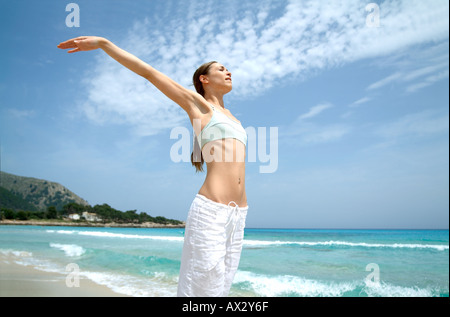 Beach wellness young woman doing a yoga excercise well being wellbeing wellness serene fit fitness vitality Stock Photo