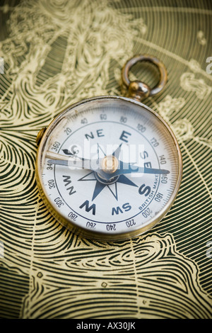 Vintage compass resting on a world map Stock Photo