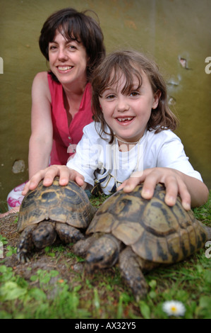 A CHILD WITH HER MOTHER WITH TWO TORTOISES IN PETS CORNER AT LONGLEAT SAFARI PARK NEAR WARMINSTER WILTSHIRE Stock Photo