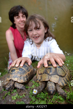 A CHILD WITH HER MOTHER WITH TWO TORTOISES IN PETS CORNER AT LONGLEAT SAFARI PARK NEAR WARMINSTER WILTSHIRE Stock Photo
