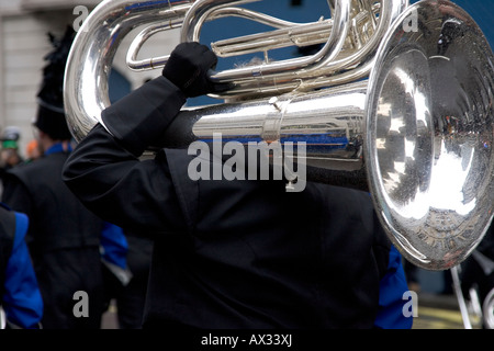 A brass band member carrying and playing the euphonium at the Saint Patrick s Day street parade Trafalgar Square London 2008 Stock Photo