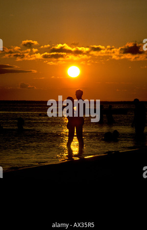 Isla Mujeres Quintana Roo Mexico A couple embraces on the beach at sunset Stock Photo