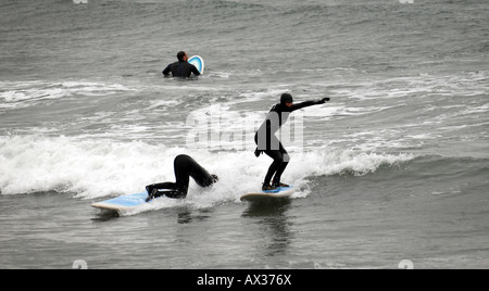 SURFERS LEARNING TO SURF  AND FALL AT A  SURF SCHOOL IN BIGBURY ON SEA,DEVON,ENGLAND.UK Stock Photo