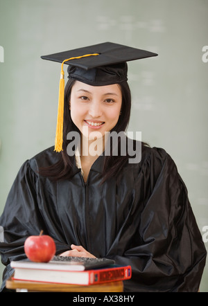 Asian woman wearing graduation cap and gown Stock Photo