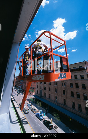 Construction workers in cherry picker outside high rise building Denver Colorado USA Stock Photo