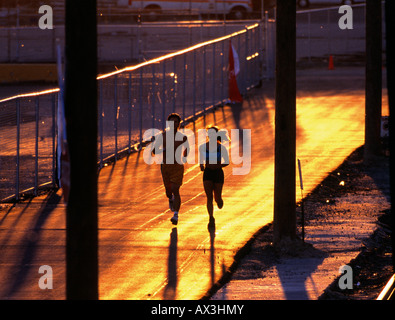 Couple Jogging at sunset on city street Stock Photo