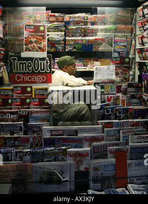 A newspaper vendor sitting in his booth in a Chicago Street scene. Stock Photo