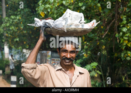 Man carrying large tray on his head, Kerala, India Stock Photo