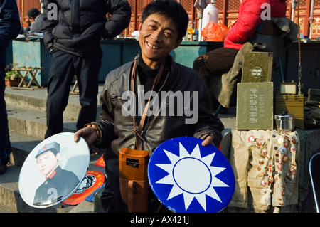 China, Beijing, Baoguo temple. A vendor selling war memorabilia at the antiques market. Stock Photo