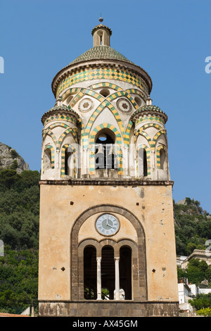 The cylindrical 12th century bell tower with yellow and green tiles above arches framing a set of bells in Amalfi, Campania, Italy Stock Photo