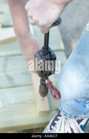 Female woodworker working outdoors with hand drill Stock Photo